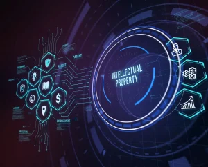 A futuristic, high-tech digital interface featuring a central glowing blue circle with the text "INTELLECTUAL PROPERTY." To the right, three glowing hexagonal icons display a person in a suit, interlocking gears, and an upward-trending bar graph. The background is a dark, abstract blend of purple and blue geometric digital elements.